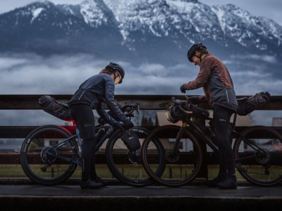 Two cyclists in a foggy mountain landscape