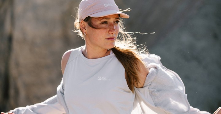 Woman in a pastel-coloured hiking outfit looking sideways